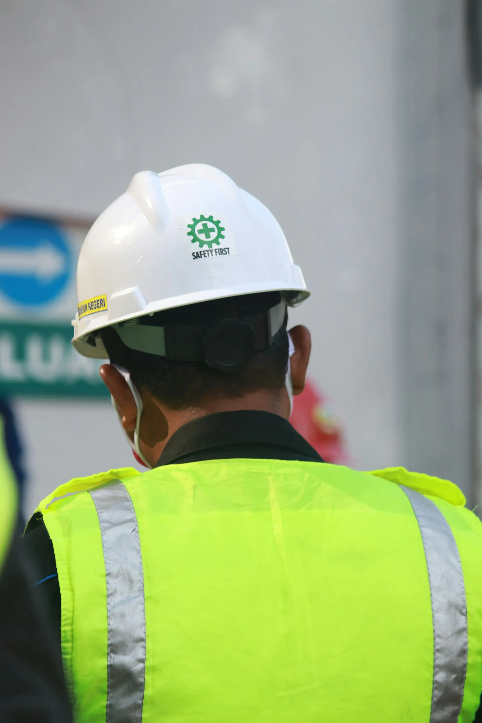 Worker in a white hard hat and hi-vis vest